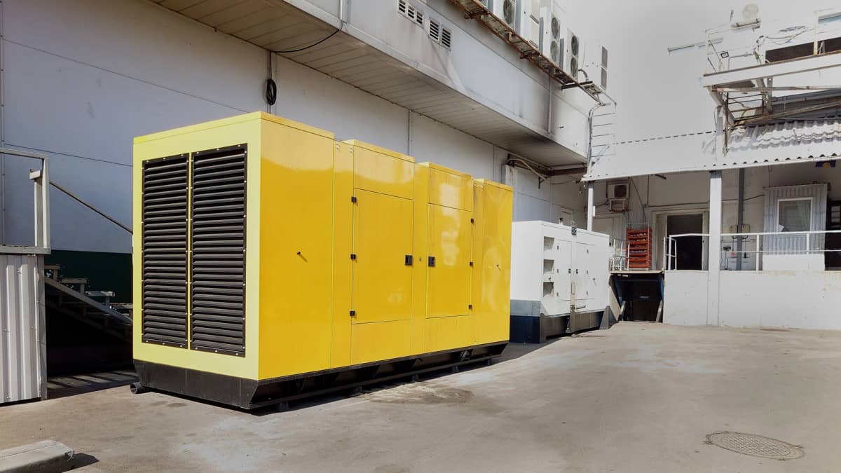Velik rumen generator na industrijskem dvorišču